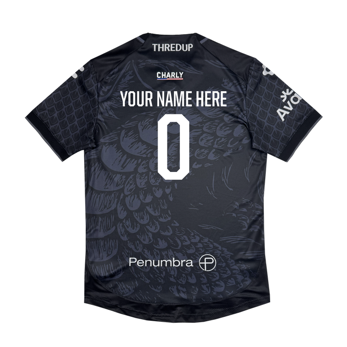 The Custom Unisex Oak-ness Awakens Kit by Oakland Roots SC is a black athletic jersey with scale patterns inspired by Oakland folklore and the mythical Oak-ness Monster, “YOUR NAME HERE,” a large white 0, and sponsor logos: Penumbra, CHARY, THREDUP, and AVO.