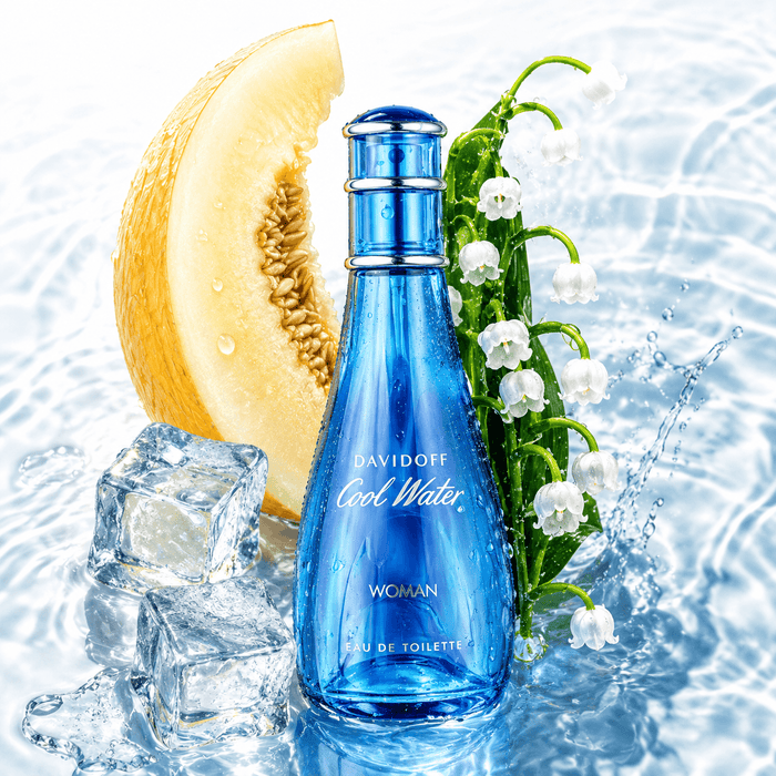 Davidoff Cool Water Woman EDT blue glass perfume spray bottle with silver cap, shown with white flowers and melon