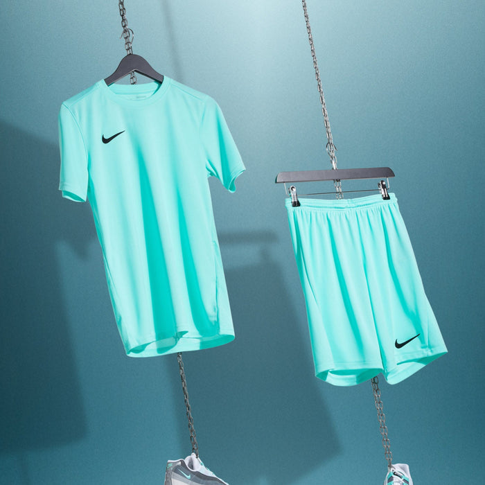 Teal sports outfit with Nike logo on shirt and shorts against a blue background