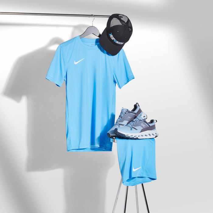 Blue athletic outfit with Nike logo, including t-shirt, shorts, and sneakers, on a white background.