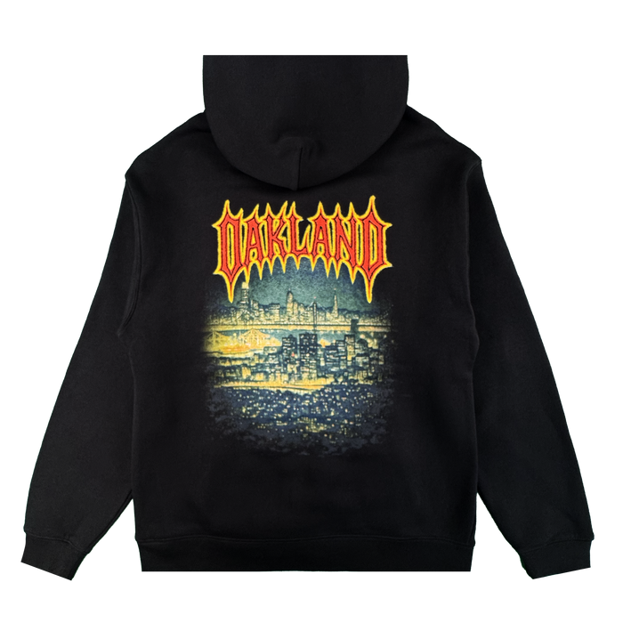 The Oaklandish Ember Hoodie is a black fleece pullover with a vibrant, stylized nighttime Oakland cityscape graphic on the back and "OAKLAND" in bold yellow-and-red flame letters. Unisex design.
