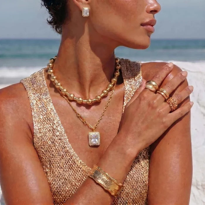 Emerald-Cut Zirconia Halo Necklace in gold tone, with a fine chain and square halo pendant, worn with matching stud earrings
