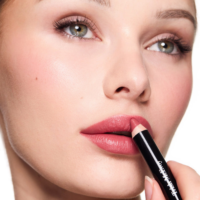 Close-up of a woman applying essential pencil nude