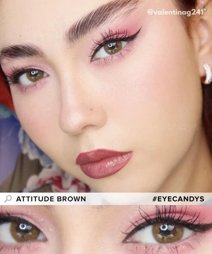 A close-up of a woman with flawless skin, bold brows, winged eyeliner, pink eyeshadow and lipstick, wearing EyeCandys Attitude Glitter Set (For Party Looks). Zoom on her eyes. Text: "ATTITUDE BROWN" and "#EYECANDYS".