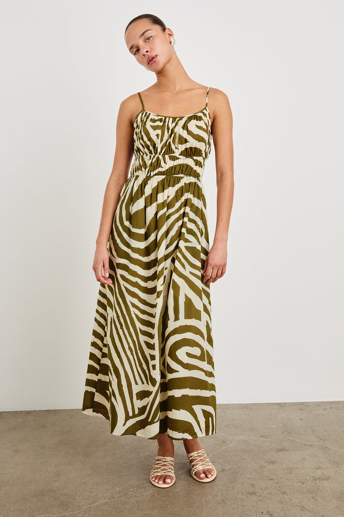 Fatima full length dress with hand painted abstract design, smocked waist, and spaghetti straps in Selva - front view on model, full body with head tilted