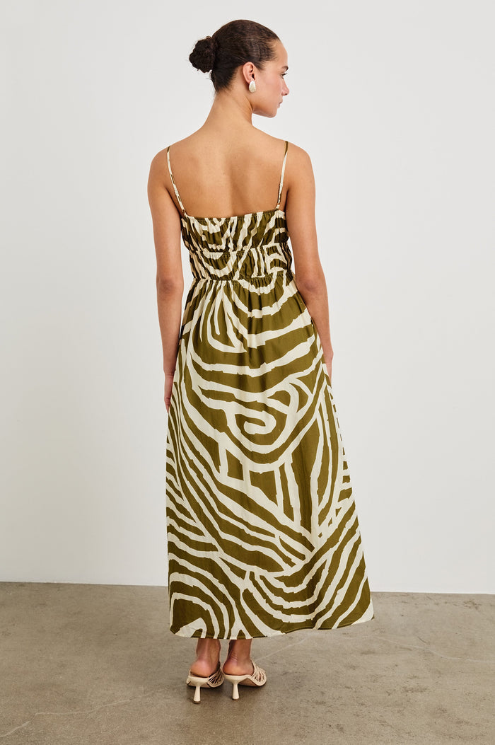 Fatima full length dress with hand painted abstract design, smocked waist, and spaghetti straps in Selva - back view on model with smocking details