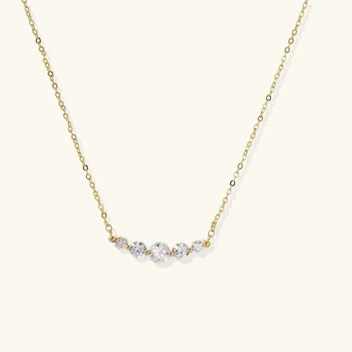 Golden Arc Zirconia Necklace with a fine gold-tone chain and five clear round stones in a graduated curved pendant