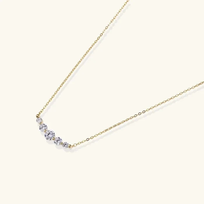 Golden Arc Zirconia Necklace with a fine gold-tone chain and five clear round stones in a graduated curved pendant