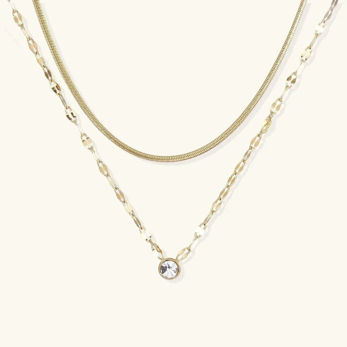 Golden Hour Layers necklace with two gold-tone chains, a fine snake chain and flat-link chain with round crystal pendant