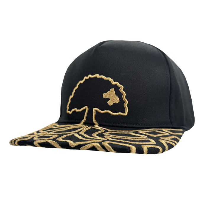 The Oakland Roots SC Growth Cap is a black 5-panel hat with gold embroidery. It features a stylized gold tree on the front and an abstract gold line pattern on the brim, creating a bold, signature look.