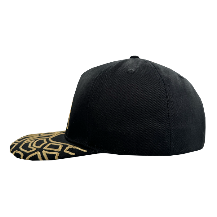 The Oakland Roots SC Growth Cap is a black 5-panel, structured fitted cap with a plain crown and flat brim featuring an abstract gold geometric pattern, displayed from the side against a white background.