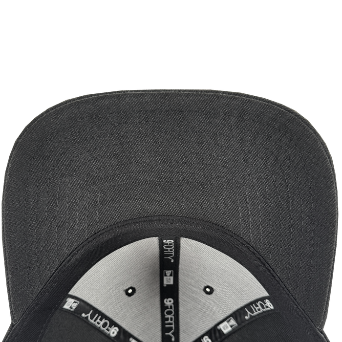 A top-down view of the GSV Logo 9FORTY Snapback by GSV shows the black flat-brim hat’s interior with light gray panels, black seams featuring “9FORTY” and New Era logos in white, and a black brim, set against a plain white background.