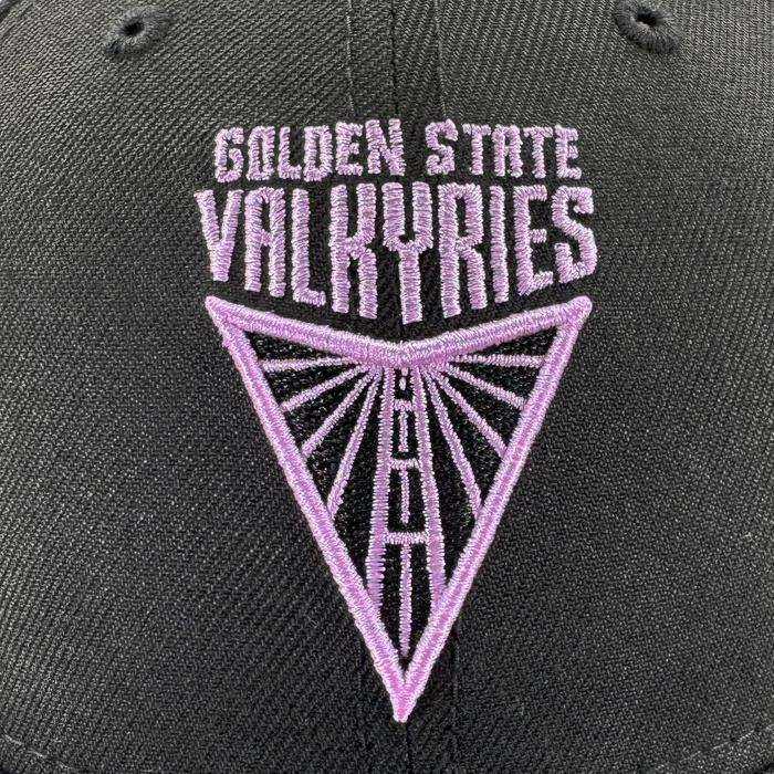 Close-up of the GSV Logo 9FORTY Snapback by GSV, a black hat with purple "GOLDEN STATE VALKYRIES" embroidery above a geometric, radiant inverted triangle logo.