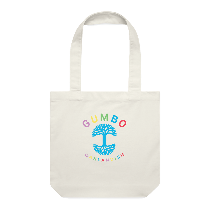 The GUMBO x Oaklandish Tote by Oaklandish is a contemporary canvas tote bag featuring two handles and a colorful design. It showcases the word "GUMBO" in rainbow colors at the top, a blue tree with spreading branches in the middle, and "OAKLANDISH" in rainbow colors at the bottom. This streetwear piece centers around vibrant tree imagery.