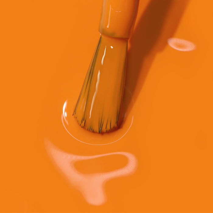Close-up of a paintbrush dipped in LONDONTOWN's vibrant Heat Wave paint.