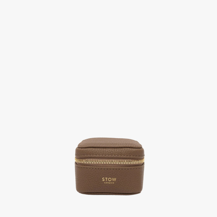 STOW London's Hester Jewellery Case in Mocha pebbled leather on a light grey background featuring a YKK Natulon zip and fine gold embossed logo on the front
