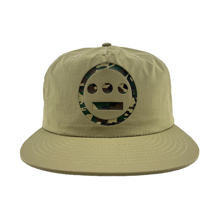 The Other Hiero Classic Camo Logo Hat is a khaki snapback cap with a flat brim. It features a circular green camo Hieroglyphics logo on the front, inspired by classic hip-hop style, set against a plain white background.