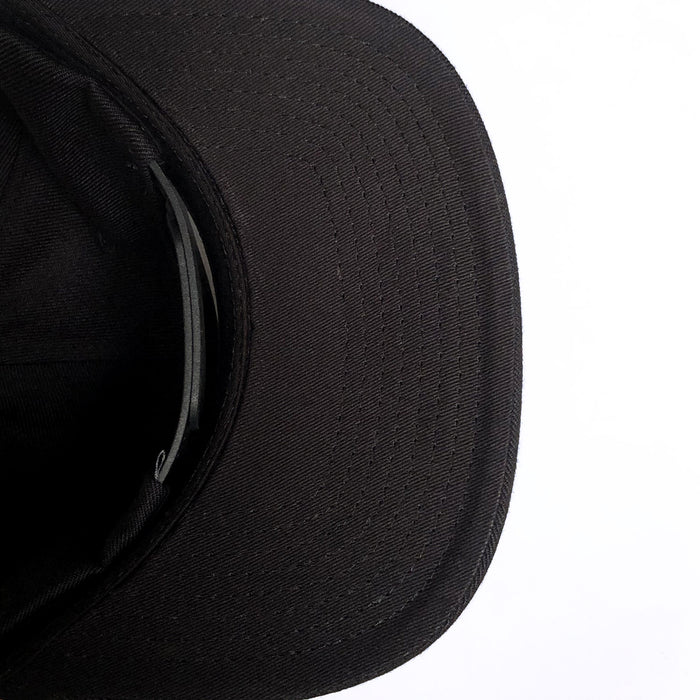 A close-up view of the Hieroglyphics Hiero Crew Snapback, a black baseball cap, positioned with its brim facing the top-right corner of the image. The stitching details are visible on the brim, and the inner band and part of the crown are shown in shadow. The background is plain white, contrasting with the dark color of the cap.