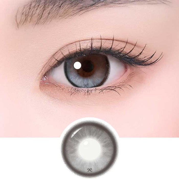 i-Sha Reborn Moon Stone color contact lens on top of a dark eye paired with subtle eye makeup and curled wispy eyelashes, above the contact lens design.