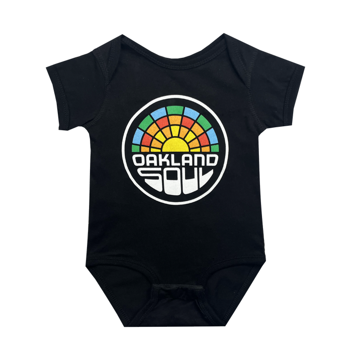 The Infant Oakland Soul Logo One-Piece from Oakland Soul is a black baby onesie that features a colorful circular logo prominently in the center. The logo displays the text "Oakland Soul" in white, set against a semi-circle of vibrant rainbow segments above it, resembling a rising sun. Inspired by the spirit of the Oakland Soul women's soccer team, this onesie comes with short sleeves and snap closures at the crotch for easy dressing.