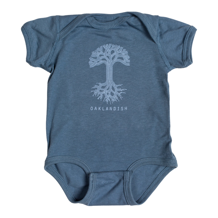 This Infant Oaklandish Classic Logo One-Piece by Oaklandish is a blue baby romper crafted from soft cotton. It features a white graphic of an intricately designed tree with symmetrical roots and branches, along with "OAKLANDISH" printed in white capital letters below the tree. The kids' onesie comes with short sleeves and leg openings that include snap closures.