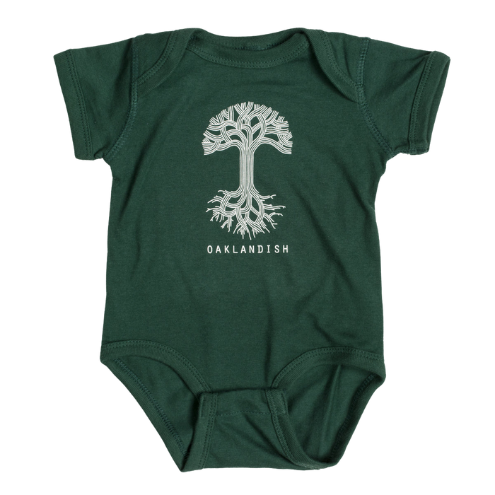 The Infant Oaklandish Classic Logo One-Piece by Oaklandish is a green baby romper showcasing a white, stylized tree with intricately designed roots and branches. Beneath the tree, "OAKLANDISH" is printed in bold, white capital letters. Crafted from soft ring-spun cotton, this short-sleeved one-piece features reinforced snap closures at the bottom for convenience.