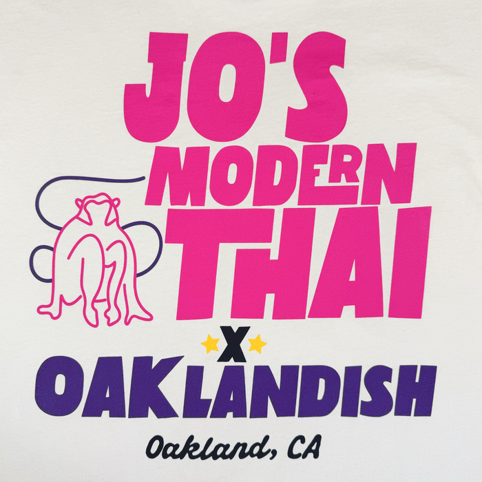 White background with bold pink and purple text reads: “Jo’s Modern Thai x Oaklandish, Oakland, CA.” An outlined frog appears on the left, with two yellow stars above “Oaklandish.” Bold, modern fonts showcase the collaboration between Jo’s Modern Thai and Oaklandish on this heavyweight Jo’s Modern Thai X Oaklandish Tee by Other—a true tribute to local creativity and partnership.