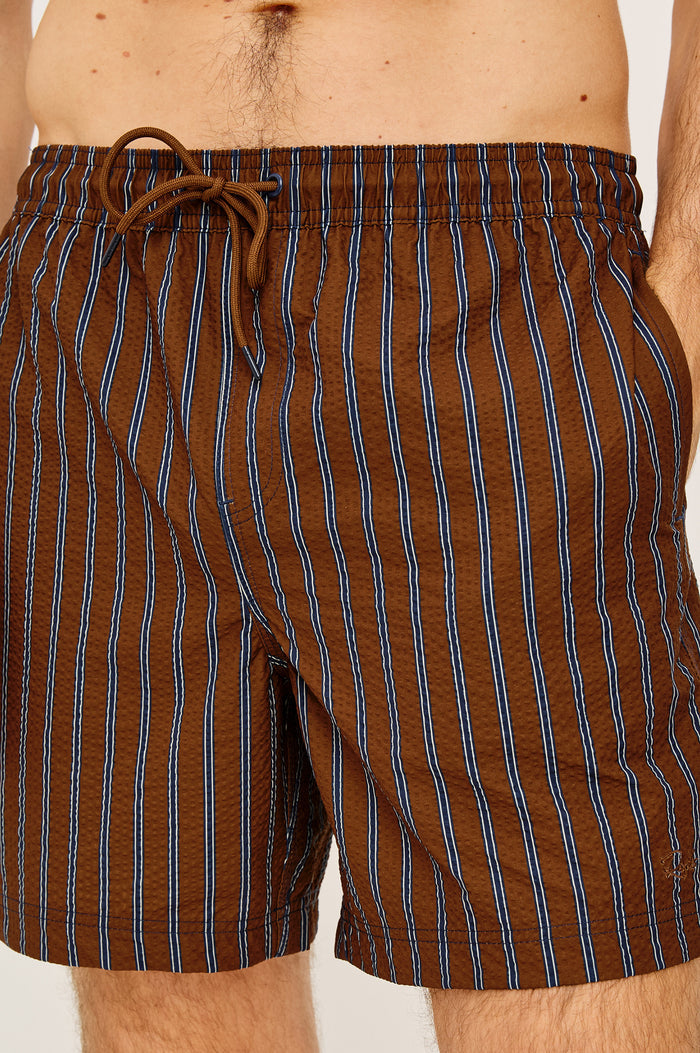 La Brea Mid-Length Swim Shorts With Adjustable Waist Drawstring Ties and Side Pockets in Rust Navy Stripe Colorway - Lower Body Front View Featured on Model