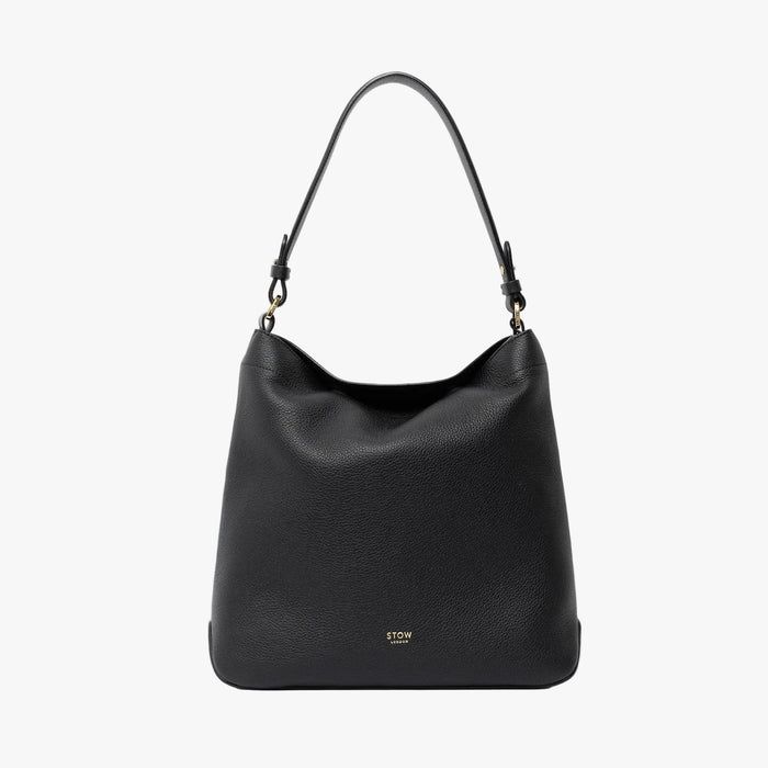 STOW London's Curve in Black leather on a light grey background featuring the detachable shoulder strap with gold hardware and details