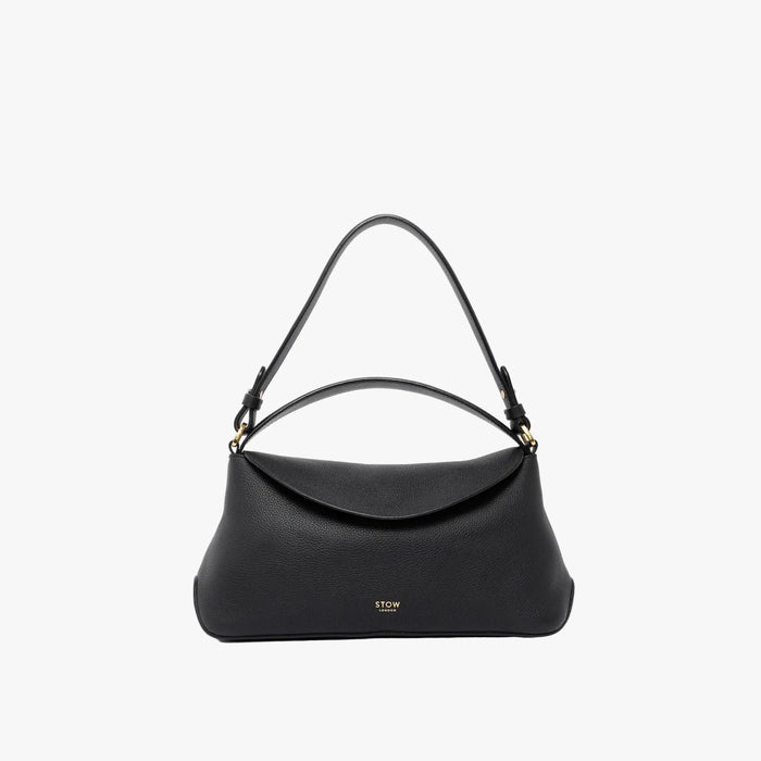STOW London's East West in Black leather on a light grey background featuring the detachable shoulder strap and top handle with gold hardware and details