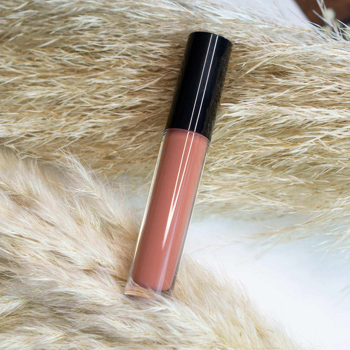 Lip Gloss - Clear in a transparent tube with peach-pink glossy liquid and a sleek black cap