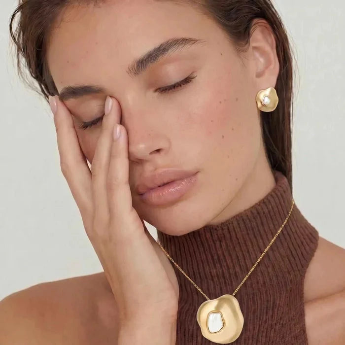 Liquid Art Sculptural Necklace in gold-tone metal with an ivory inset sculptural pendant, paired with a matching stud earring