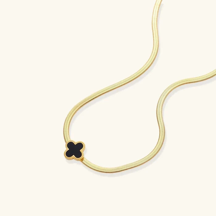 Lucky Clover Black Enamel necklace with a black four-petal pendant, beaded gold-tone border, and flat gold-tone chain