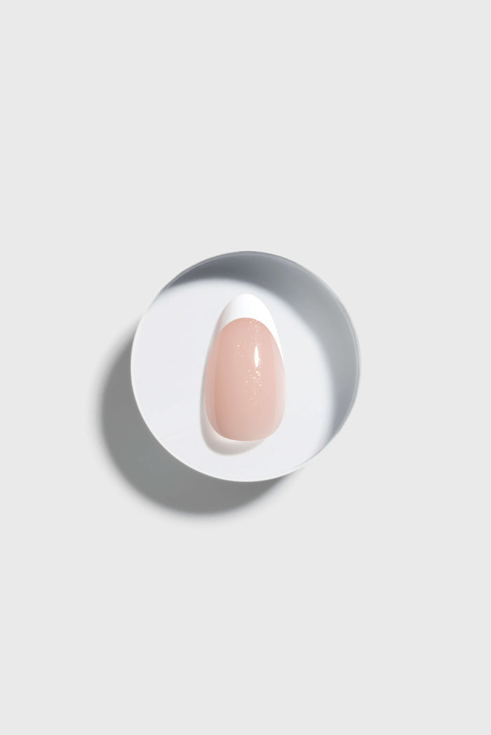 French Tip press-on nail on a white plate with a light gray background