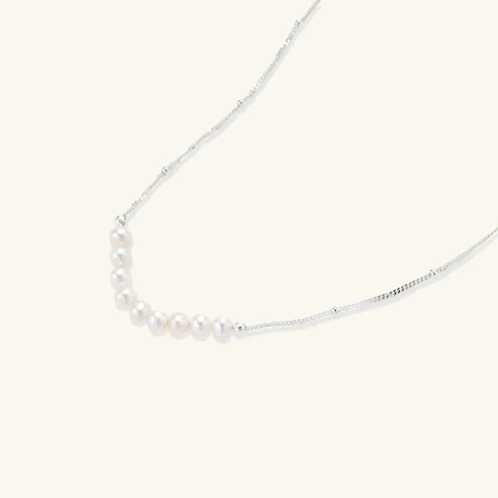Luna Freshwater Pearl Arc Necklace with nine cream pearls arranged in a curve on a delicate silver-tone beaded chain.