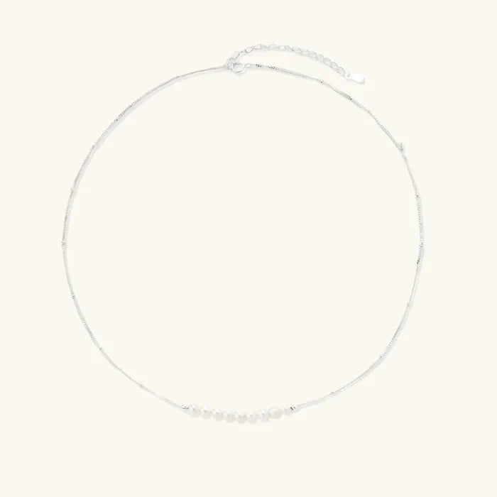 Luna Freshwater Pearl Arc Necklace in silver-tone sterling silver, with tiny cream pearls arranged in a delicate arc