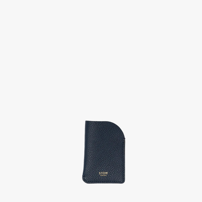 STOW London's Mini Cardholder in Navy pebbled leather on a light grey background featuring a small gold embossed logo on the front bottom