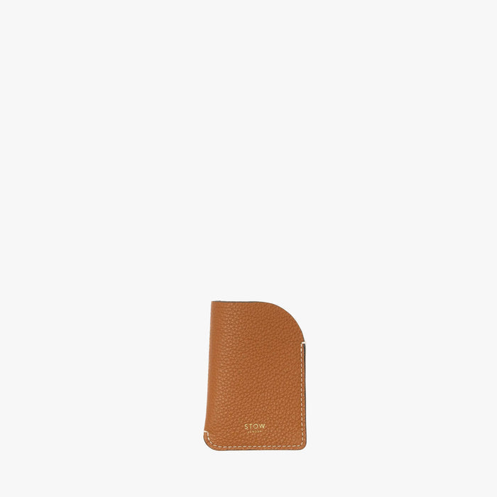 STOW London's Mini Cardholder in Earth Tan pebbled leather on a light grey background featuring a small gold embossed logo on the front bottom