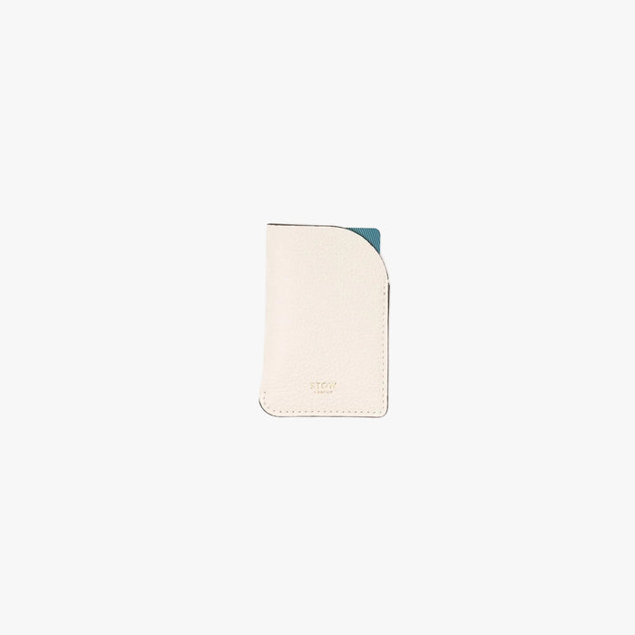 STOW London's Mini Cardholder in Spring Moon pebbled leather on a light grey background featuring a small gold embossed logo on the front bottom and blue card sticking out