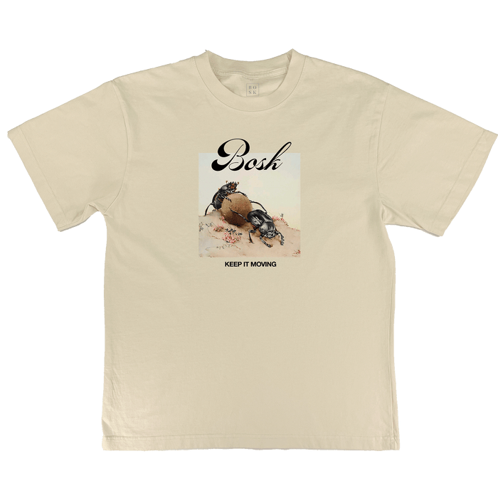 The BOSK Moving Tee is an off white, classic fit shirt featuring a dung beetle rolling a ball with small plants, “Bosh” above in script, and “KEEP IT MOVING” below the artwork.