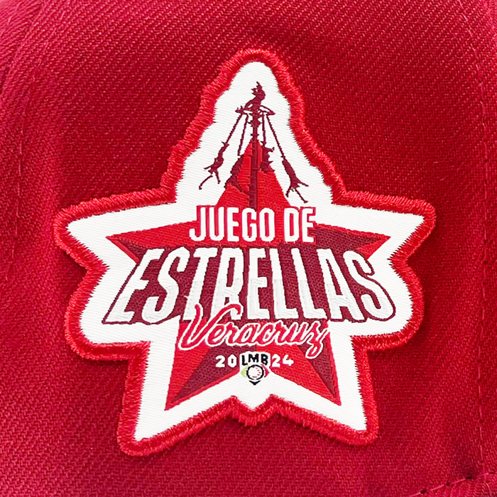 Crafted from red fabric, this New Era El Aguila Alt 59FIFTY Cap features an embroidered patch displaying a white and red five-pointed star. The patch highlights the LMB logo along with “Juego de Estrellas Veracruz 2024 LMB” in bold white and red lettering, accented by a baseball graphic at the bottom and a distinctive red lighthouse silhouette at the top—making it an ideal addition for any New Era cap collector or 59FIFTY fitted fan.