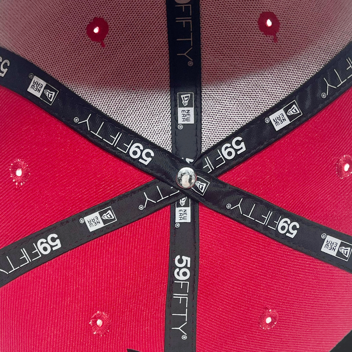 Close-up of the inside crown of a New Era El Aguila Alt 59FIFTY Cap by Other, featuring black fabric taping with brand text, a silver button at the center, and white mesh ventilation holes. The image showcases the cap’s detailed construction and premium craftsmanship.