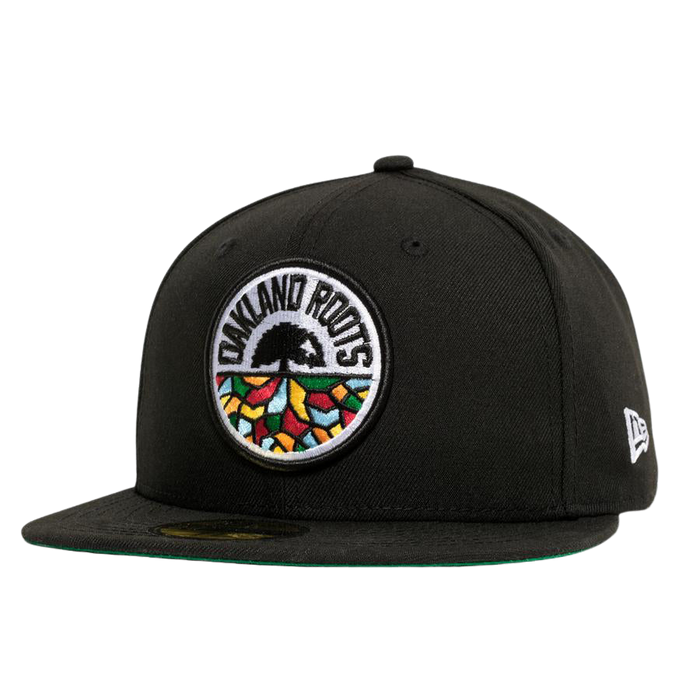 Introducing the New Era Oakland Roots SC 59FIFTY Fitted Cap: a stylish black cap featuring a colorful, circular embroidered logo on the front. This vibrant logo depicts a tree with an intricate root system and "Oakland Roots" text, symbolizing the Oakland Roots SC sports club. The cap includes a flat brim lined with green on the underside and is adorned with a small "New Era" logo on the side.