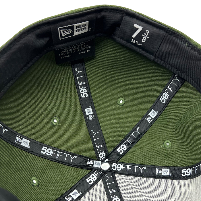 The image shows the interior of an olive green New Era Official 59FIFTY Fitted Cap by Other in size 7 (55.8 cm). The black inner tape is detailed with white “59FIFTY” branding, underscoring its authenticity as a true fitted cap. The sweatband inside is black, and metal rivets are visible on the olive green panels.