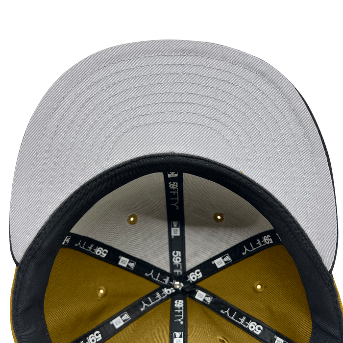 Top-down view of a yellow New Era Official 59FIFTY Fitted Cap’s interior, featuring a black sweatband, gold fabric lining, and visible stitching. The underside of the brim is gray, with multiple brand tags and stitched seams visible inside this fitted cap by Other.