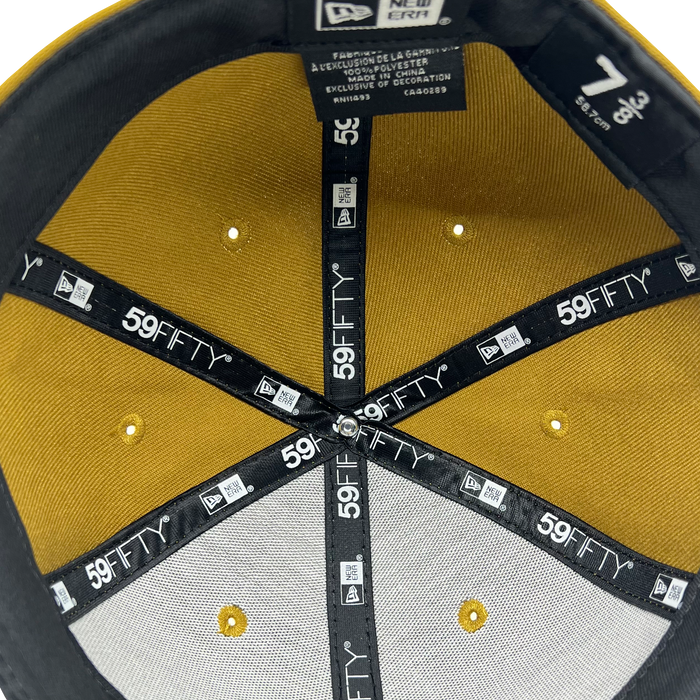 The interior of the New Era Official 59FIFTY Fitted Cap by Other in size 7 3/8 features yellow and gray panels, black branded taping, a silver rivet at the crown, and care labels sewn along the black seams.