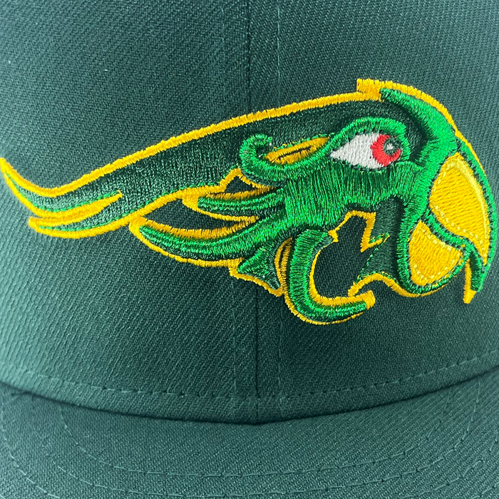A New Era Pericos 59FIFTY Cap from Other features a vibrant green design with a striking, embroidered animal head logo in green, yellow, and red—highlighted by a sweeping horn or tail outlined in yellow—on the front. The cap showcases visible stitching and rich fabric texture, complemented by an intricately detailed LMB logo on the side.