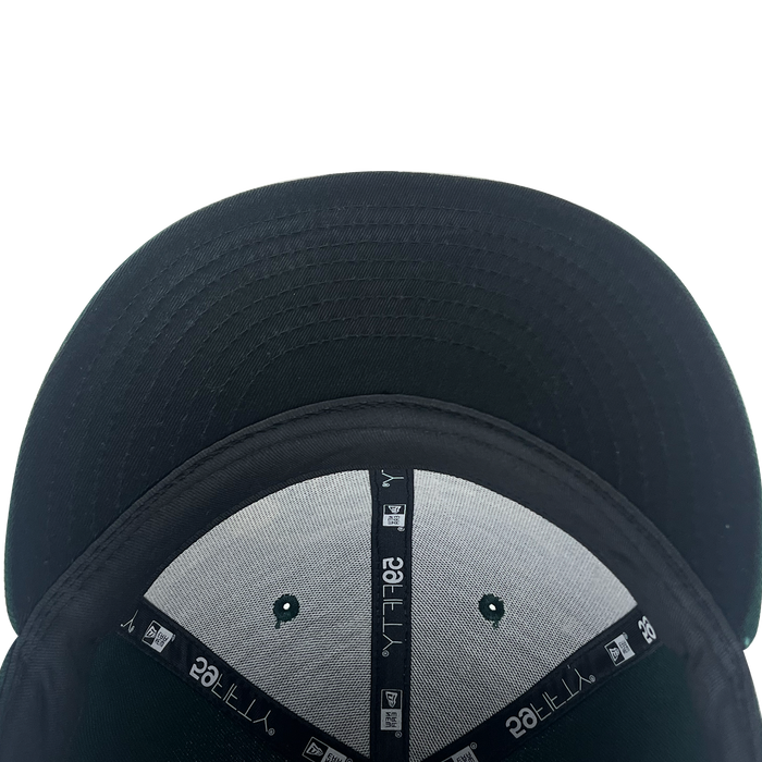 A close-up, top-down view of a black New Era Pericos 59FIFTY Cap by Other shows the underside of the brim and interior details, including stitching, labels, and ventilation holes against a white background.