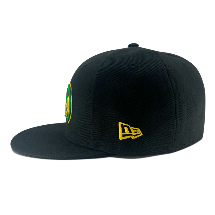 A black flat-brimmed New Era Pericos ALT 59FIFTY Cap by Other is shown from the side, featuring a small yellow New Era logo embroidered on the left and a partially visible green and yellow embroidered design on the front. This fitted cap is set against a plain white background.