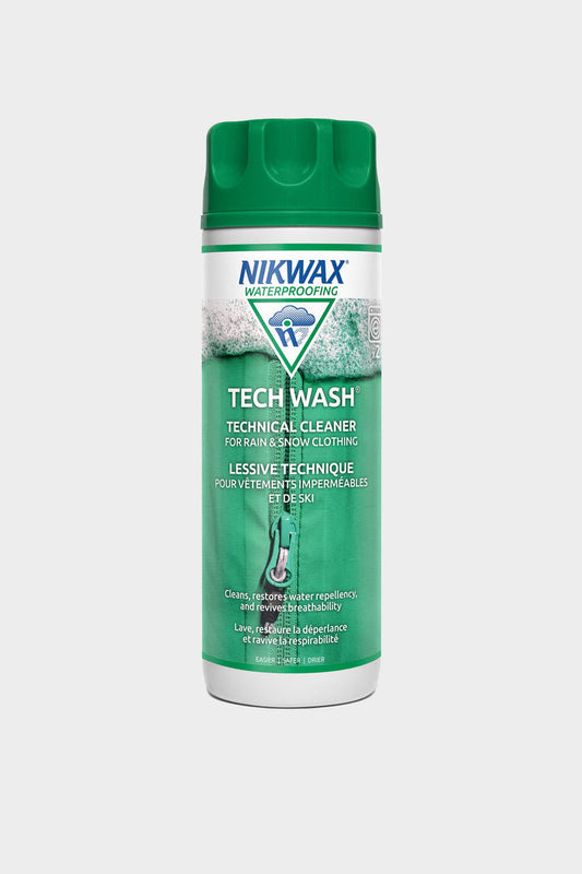 A green bottle of 686 Nikwax Tech Wash®, a cleaner for rain and snow gear, is shown against a white background. The front label features product details in English and French.